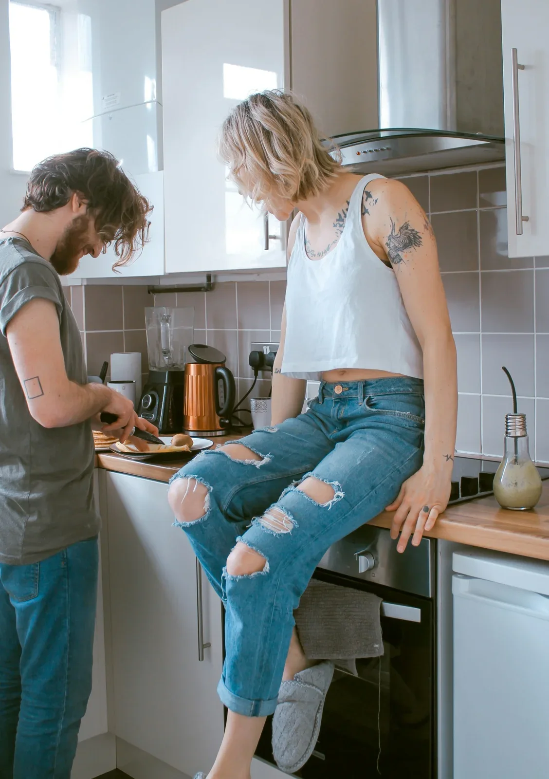 Two young adults cooking breakfast together in a kitchen